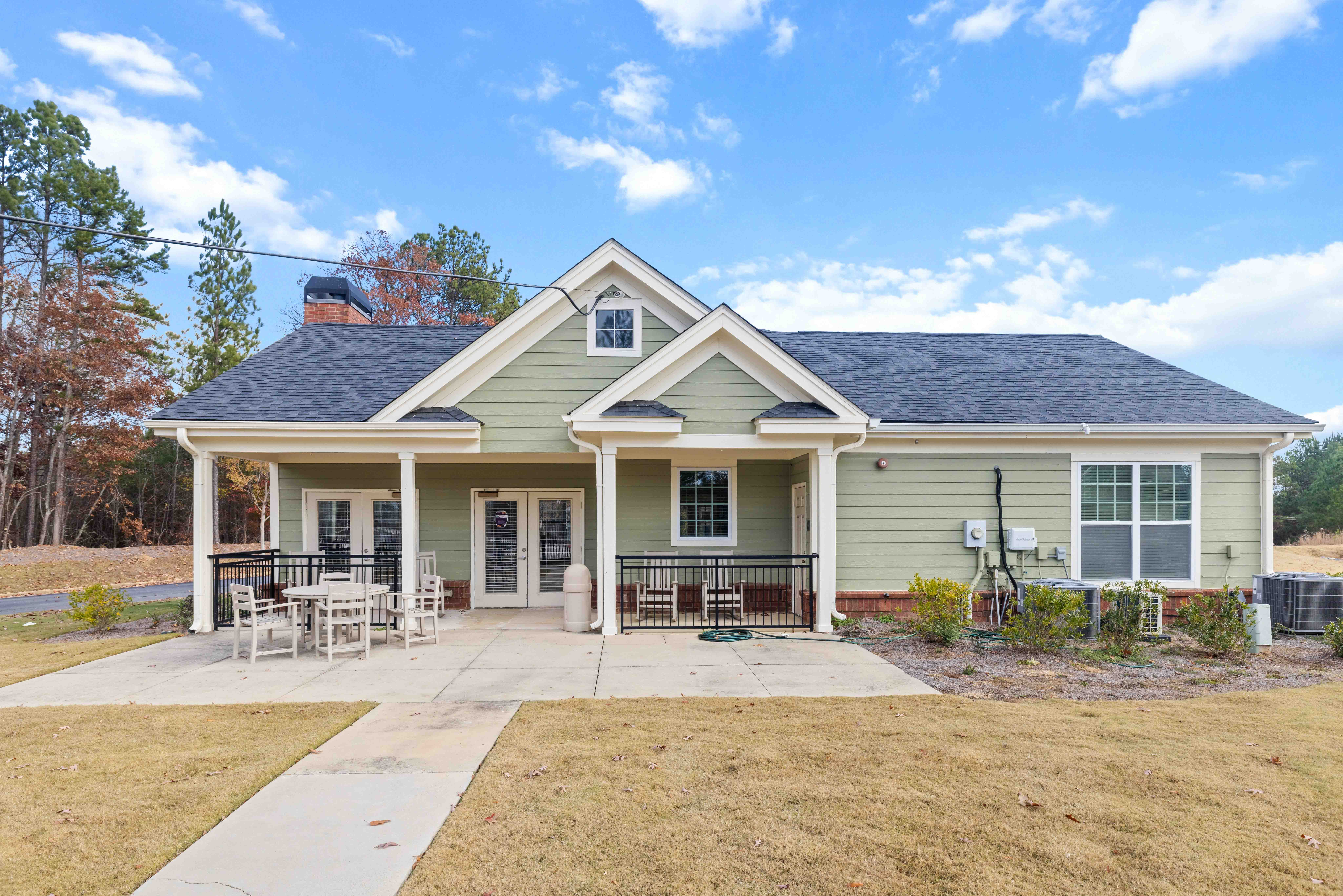 A house with a covered patio and a bicycle in the front yard.
